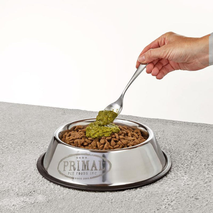 green food topper going onto dog food